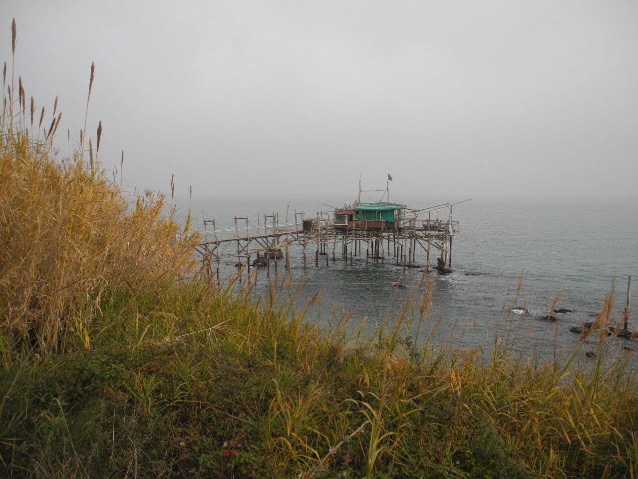 Un trabocco emerge dalla foschia sul mare